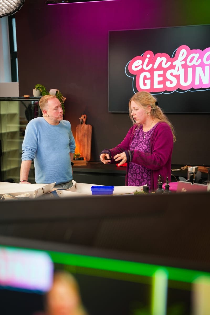 Moderationspaar einer Kochshow vor der Studioküche