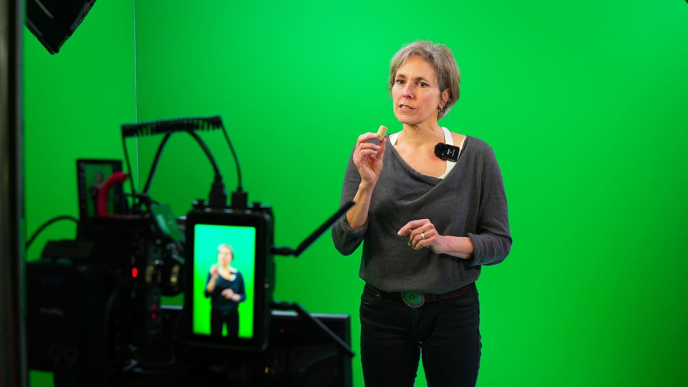 Sprecherin nimmt eine Lektion auf und liest dabei vom Monitor unter der Kamera ab