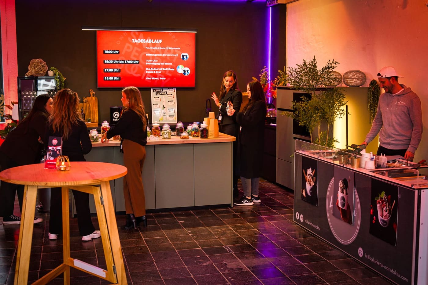 Theke im Loft, im Hintergrund der Tagesablauf auf dem Screen